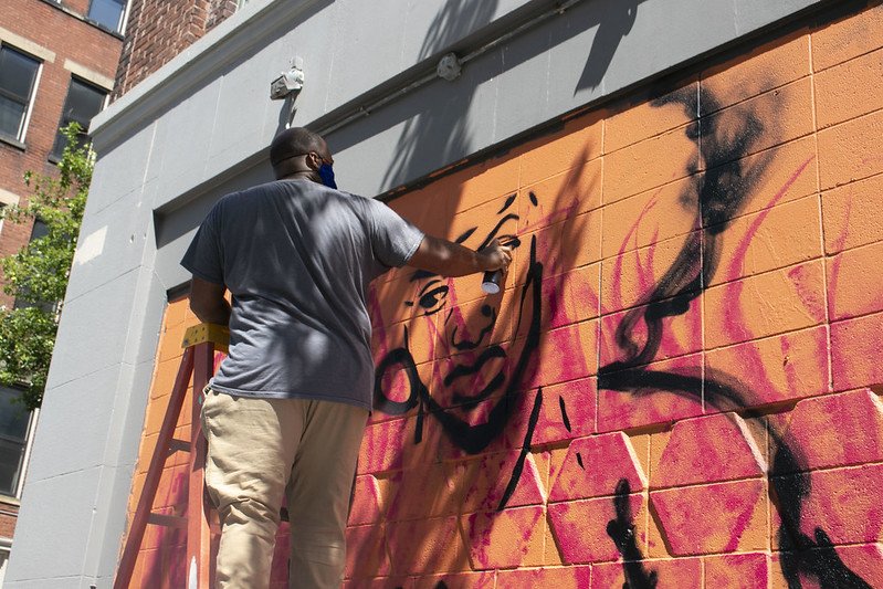 someone working on the mural outside of school