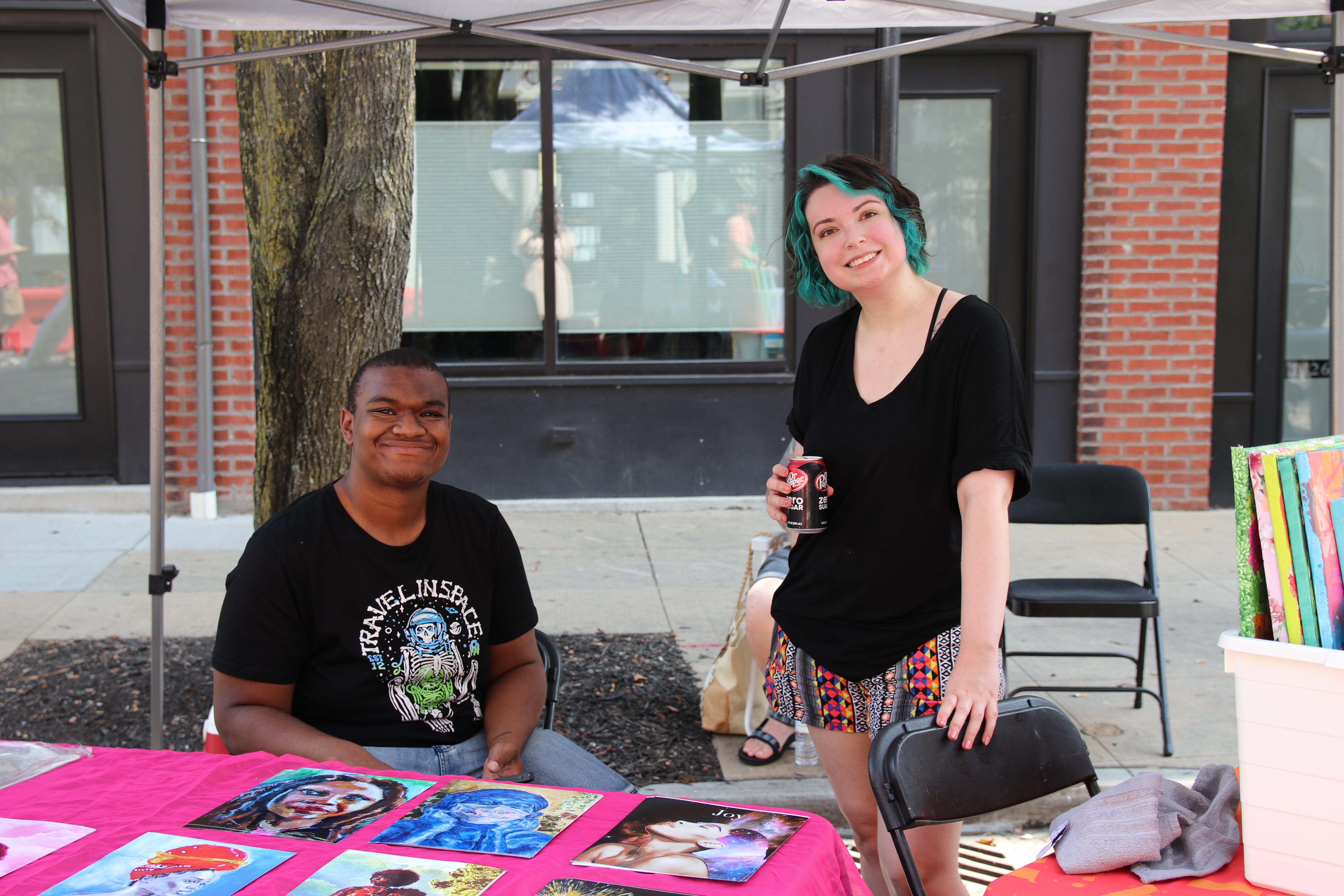 two students selling art outside