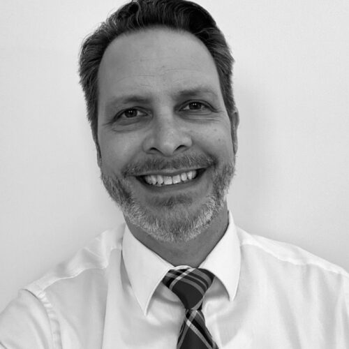 black and white headshot of man smiling