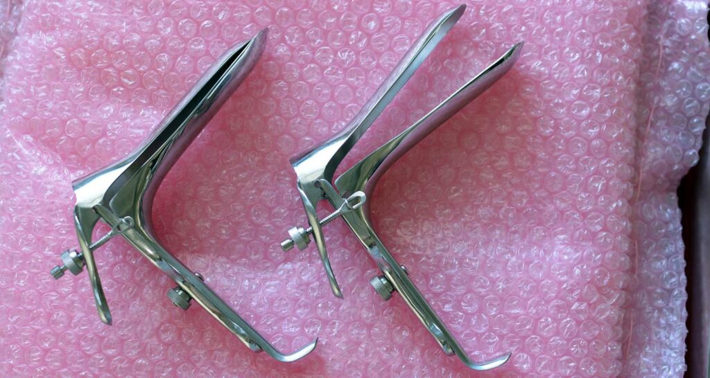 two metal speculums on pink bubble wrap