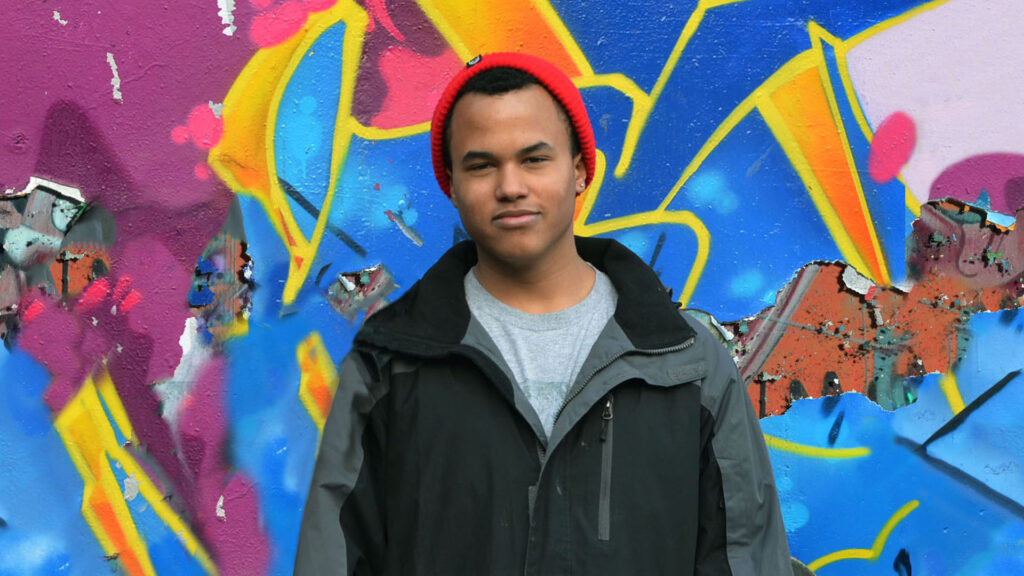 man standing in front of graffiti