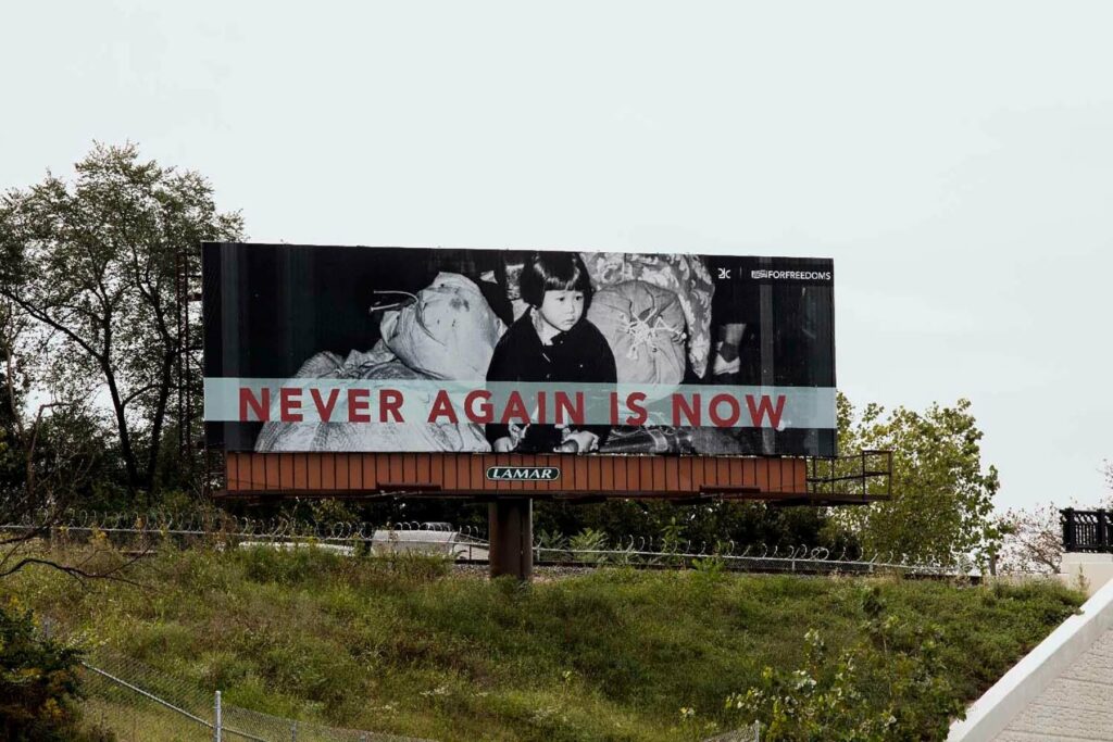 billboard of child reads "never again is now"