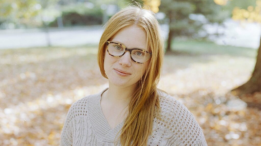 color headshot of woman with glasses smiling