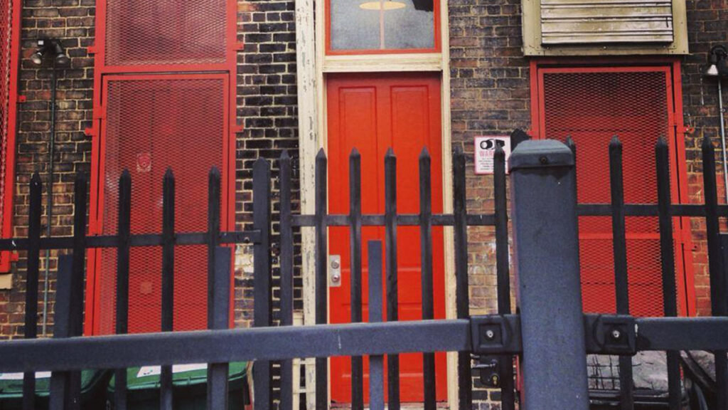 photograph of red doors behind a fence