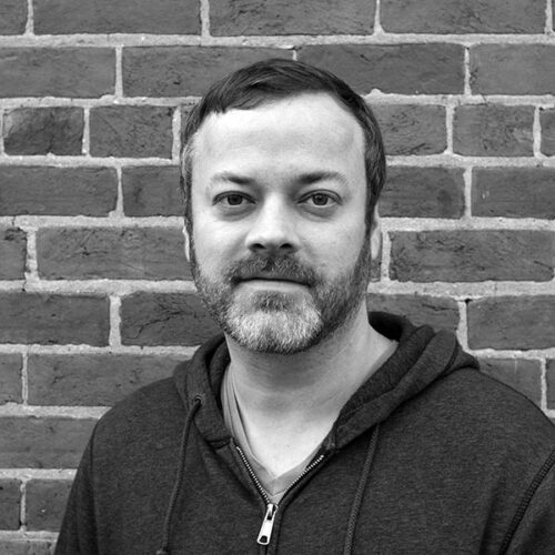 black and white headshot of man smiling