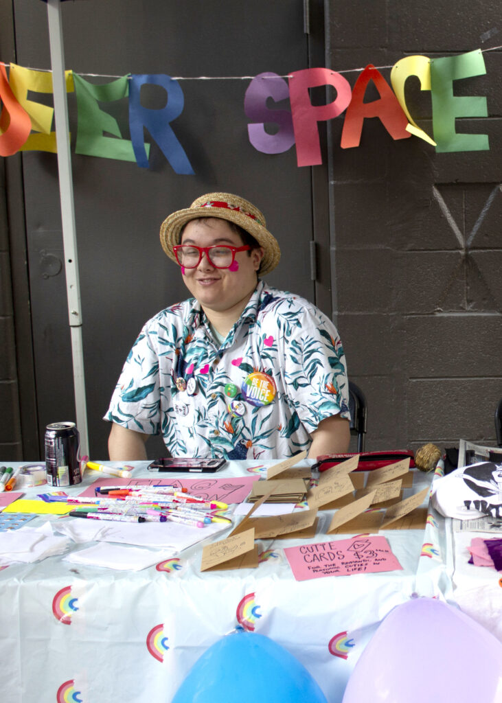 student sitting at festive queerspace table