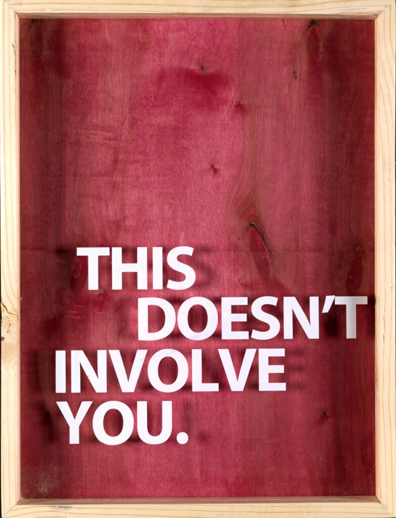red stained wood with white text reading "this doesn't involve you"