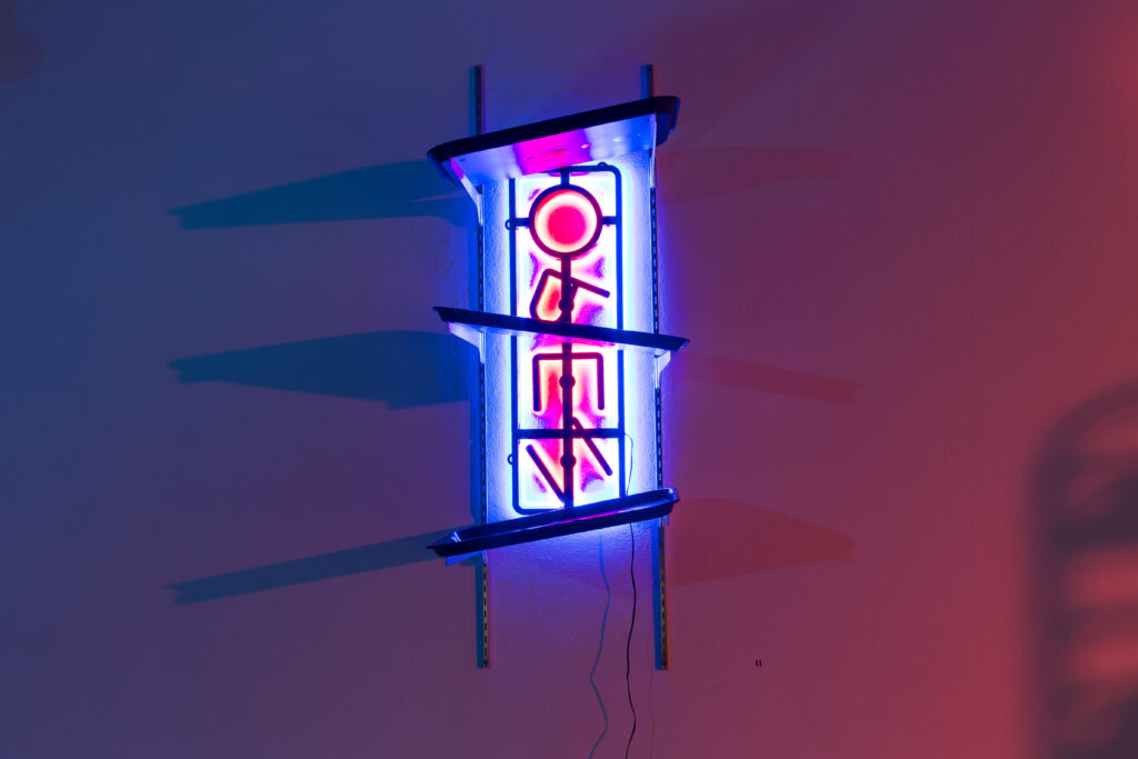 sculpture of blue and red neon open sign with letters askew