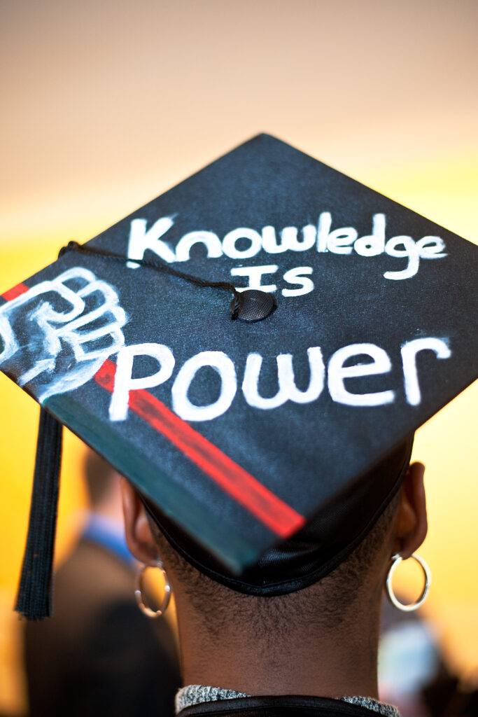 student wearing graduate cap saying knowledge is power