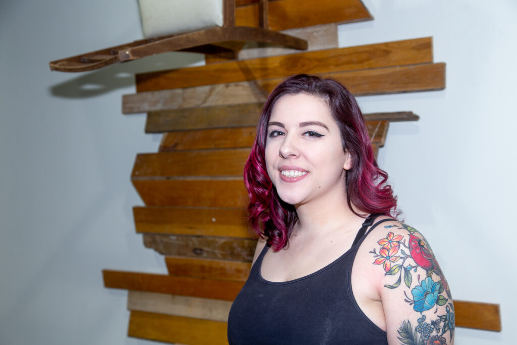 student posing in front of wood floor panel sculpture