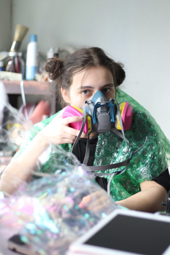 student in studio with respirator on face