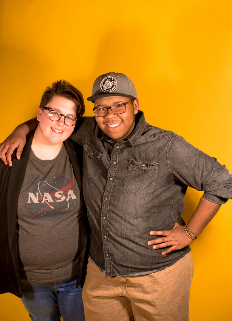 two students with yellow background