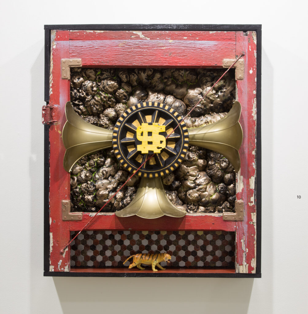 vintage brass objects collaged into red wall piece with dollar sign in center