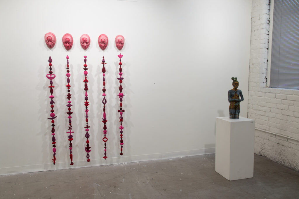 figurative sculpture, and wall sculptures with red faces and vertical red works