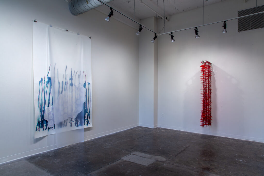 geometric wall sculptures in blue and red in gallery