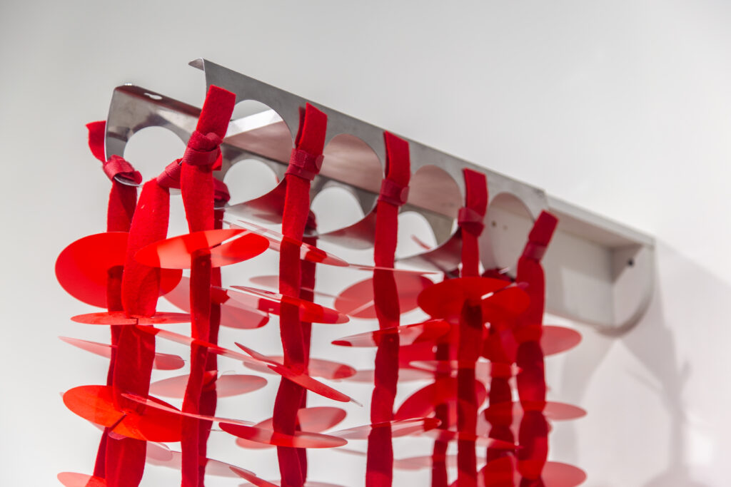 detail of red plastic circular wall sculpture