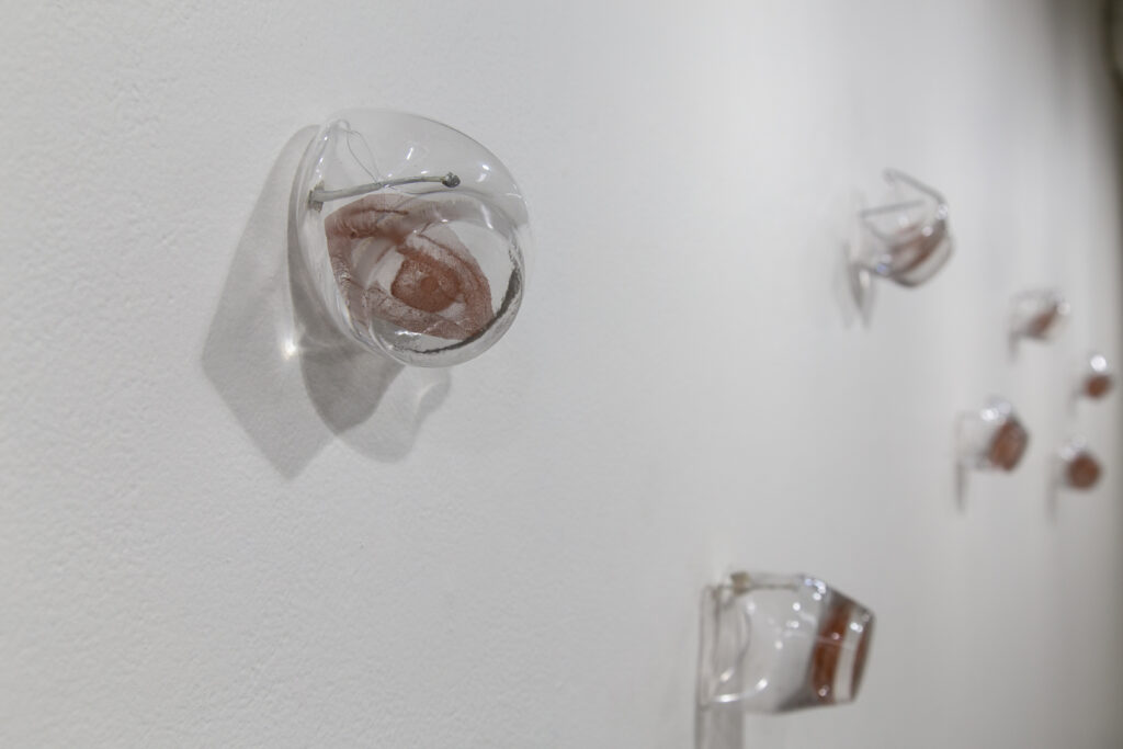 metled glass wall sculptures with eyes printed on them