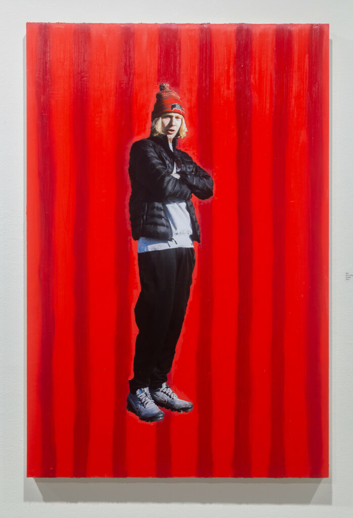 canvas painted with red stripes with cut-out photo of a standing figure