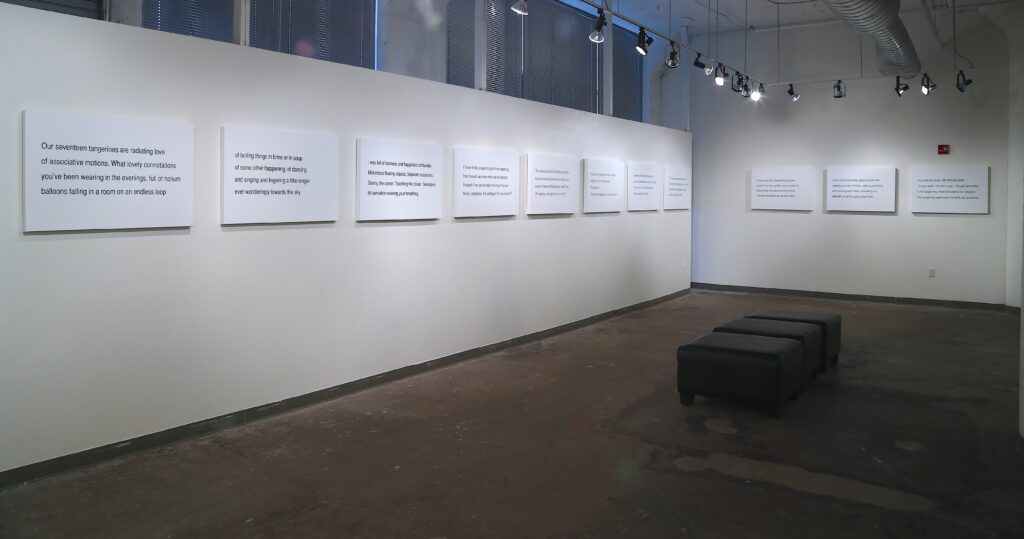 row of panels with text hanging on gallery walls