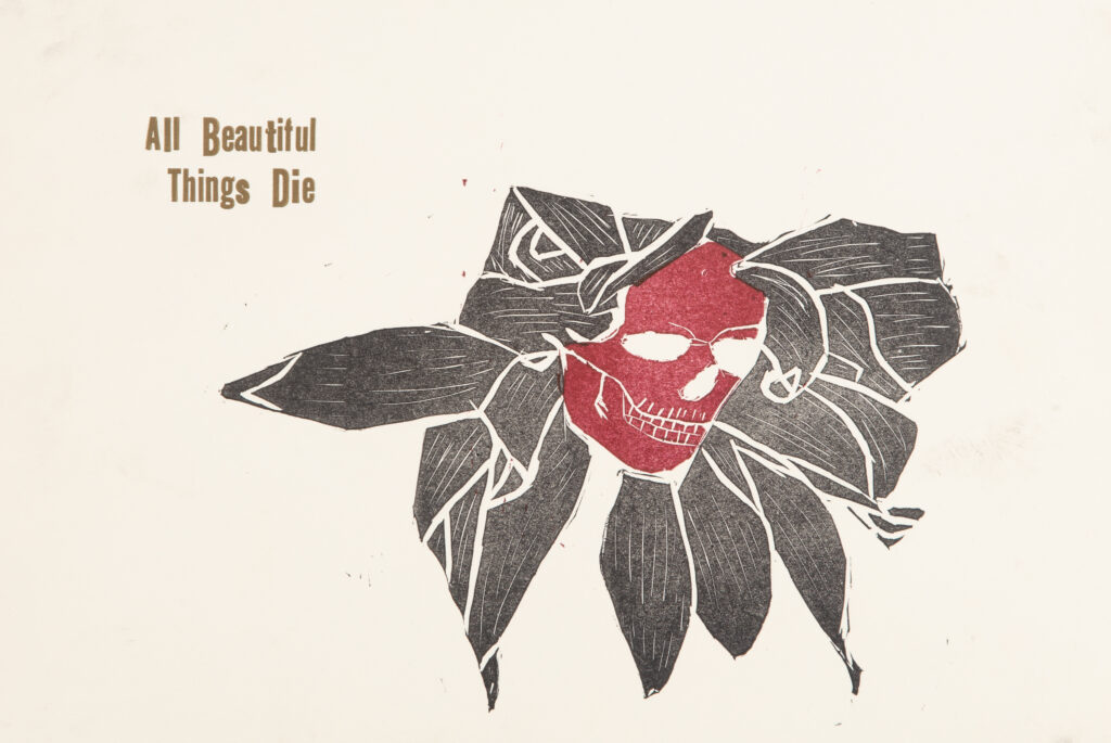 relief print of red skull and black petals reading "beautiful things die"