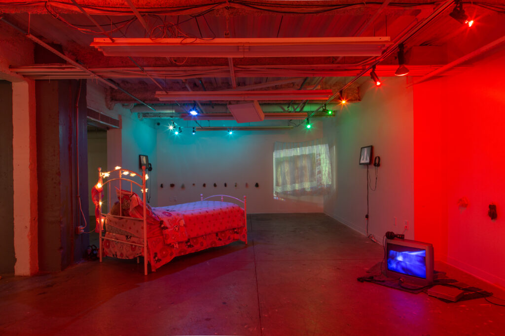 red and green room with bed and multimedia installation