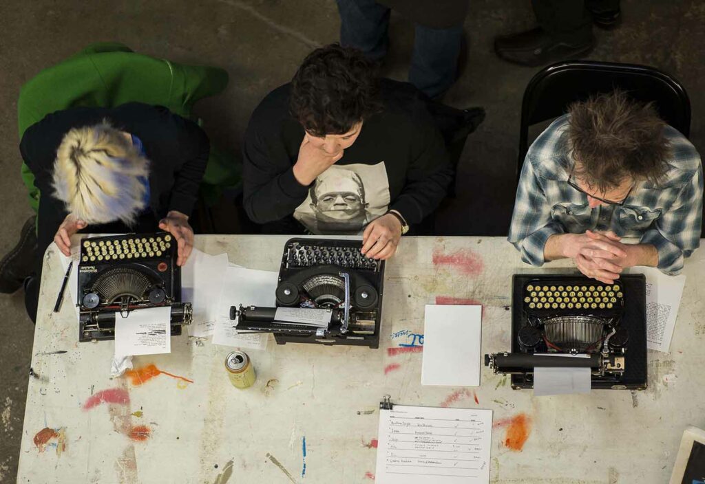 three poets writing on typewriters