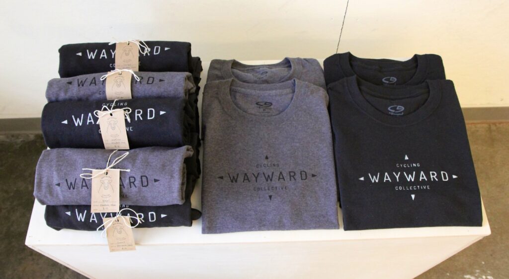 black and gray branded t shirts reading "wayward cycles"