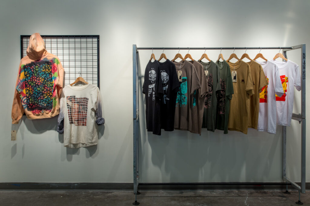 installation of hand-printed and dyed clothing hanging on racks