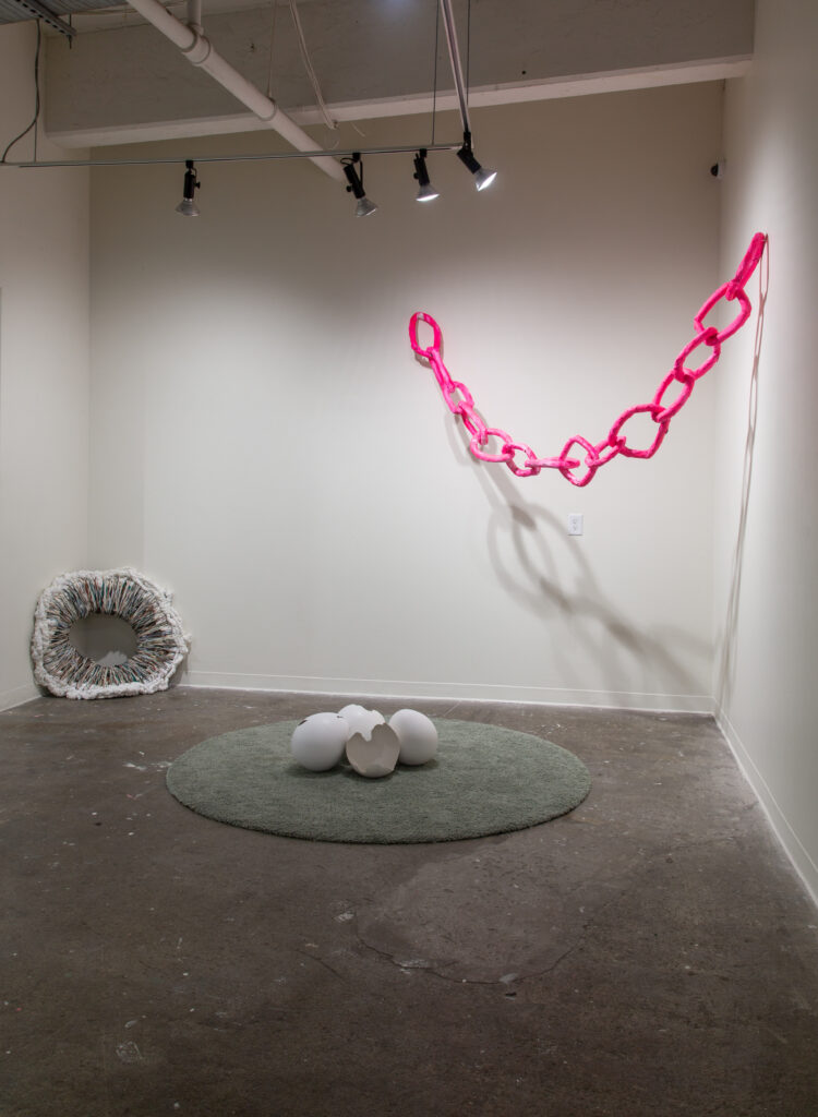 gallery with pick chain, oversized eggs on rug, and circular textile in gallery