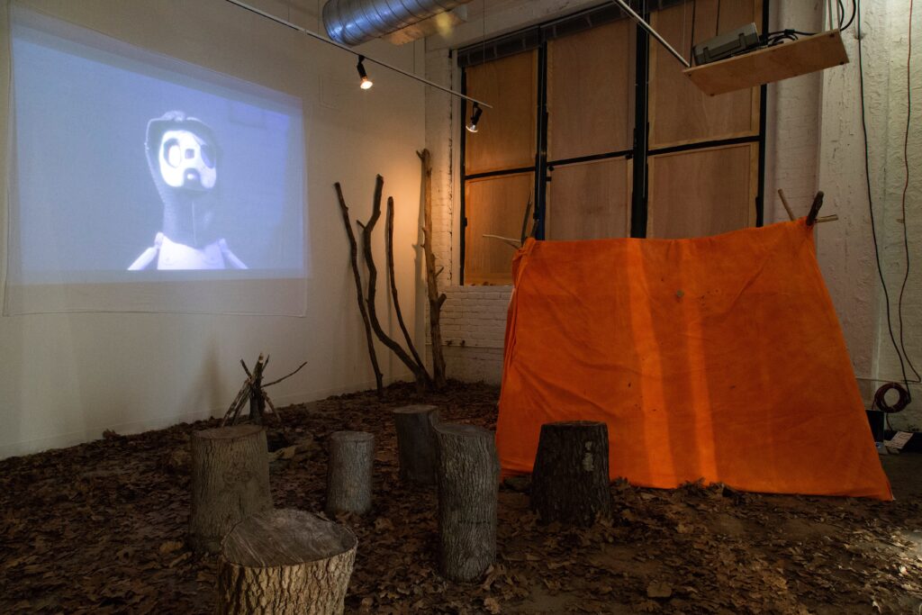 projection with logs and tent sculpture