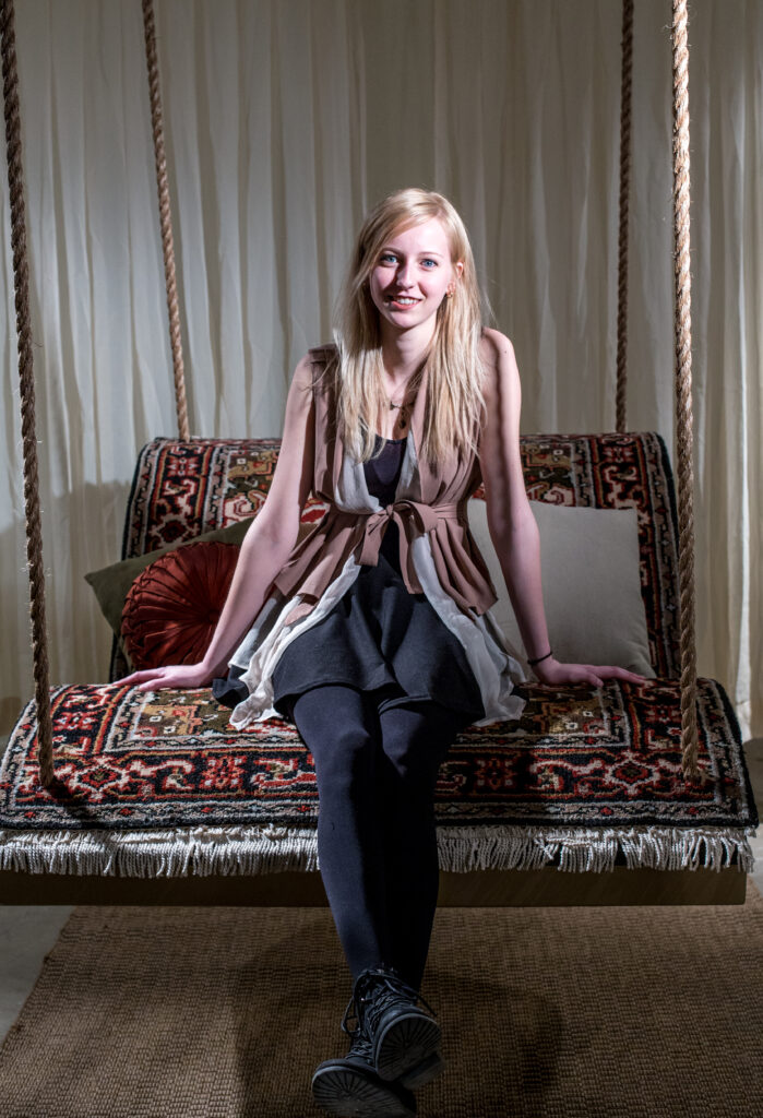 woman sitting on hanging carpet sofa