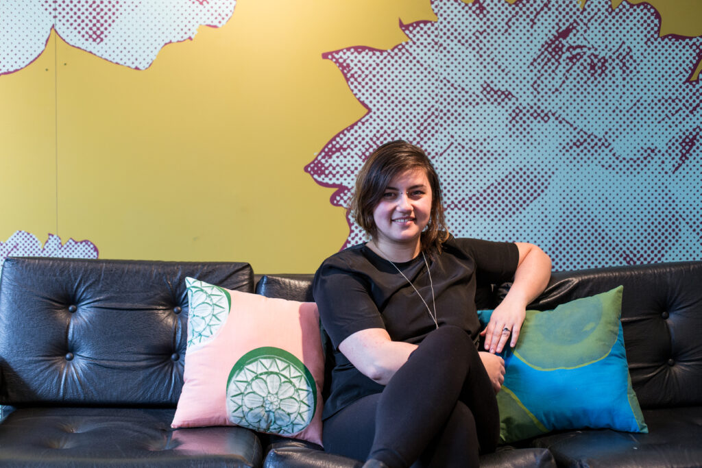 woman sitting on couch with wallpaper behind her