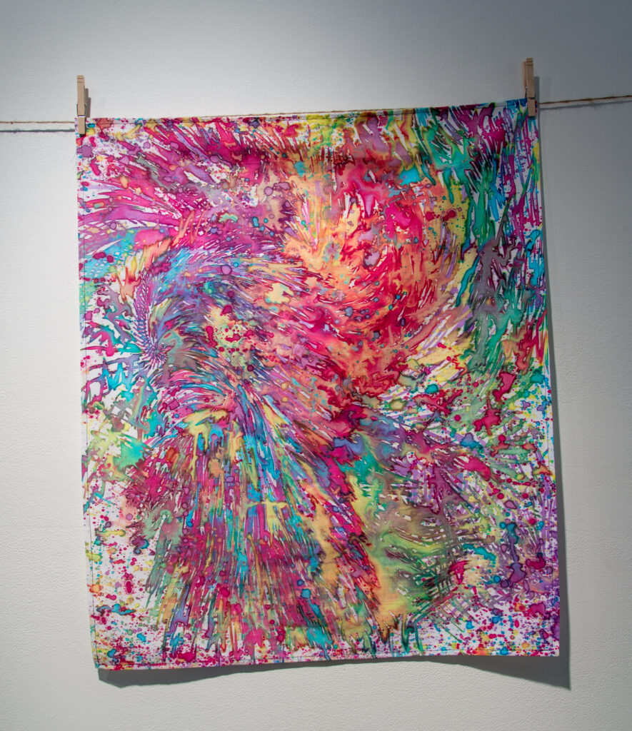 abstract print of brightly colored splattered dyes on fabric