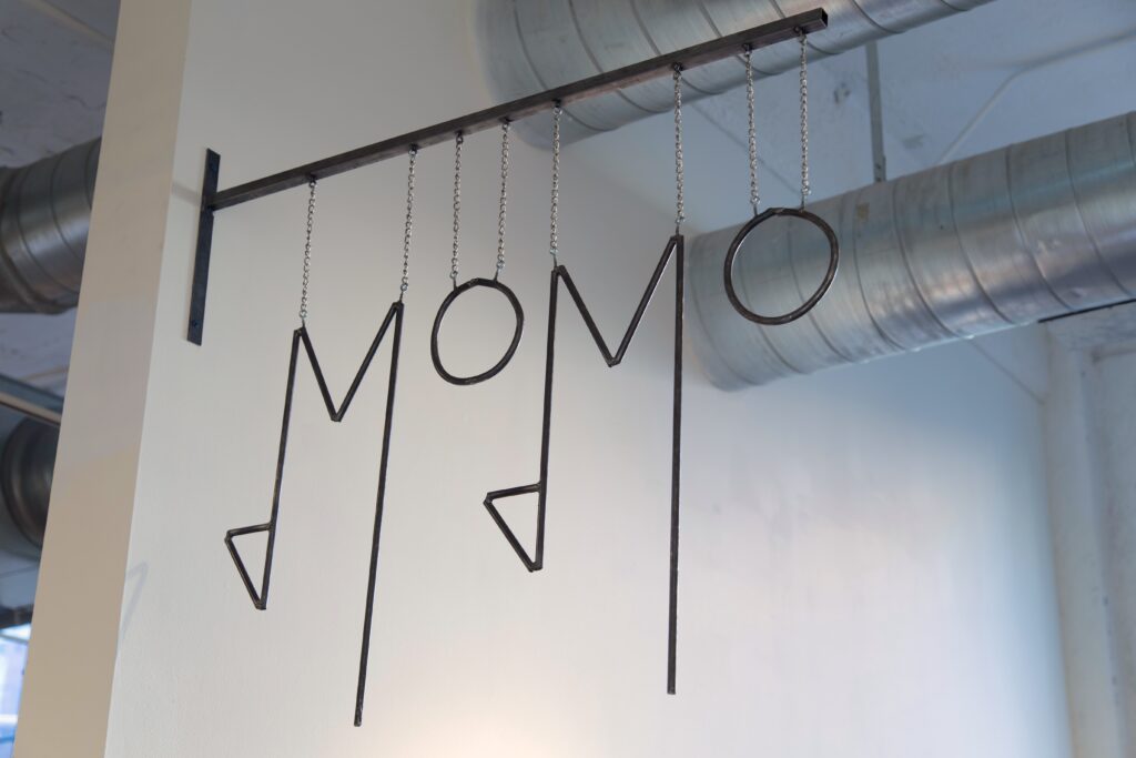 metal restaurant sign reading MOMO