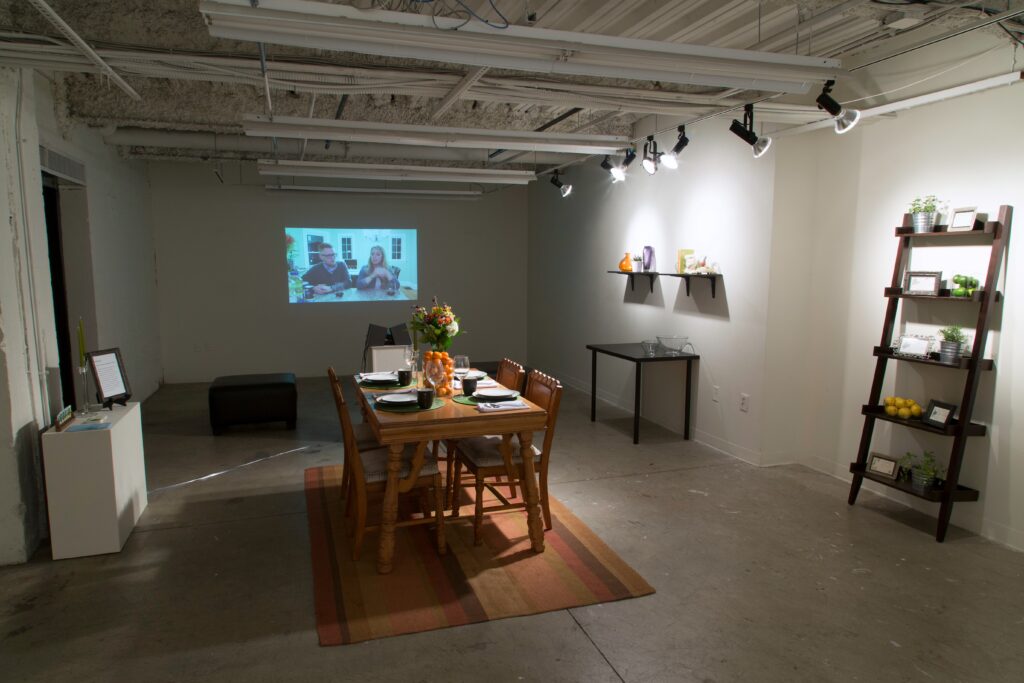 table, projector and shelves in gallery