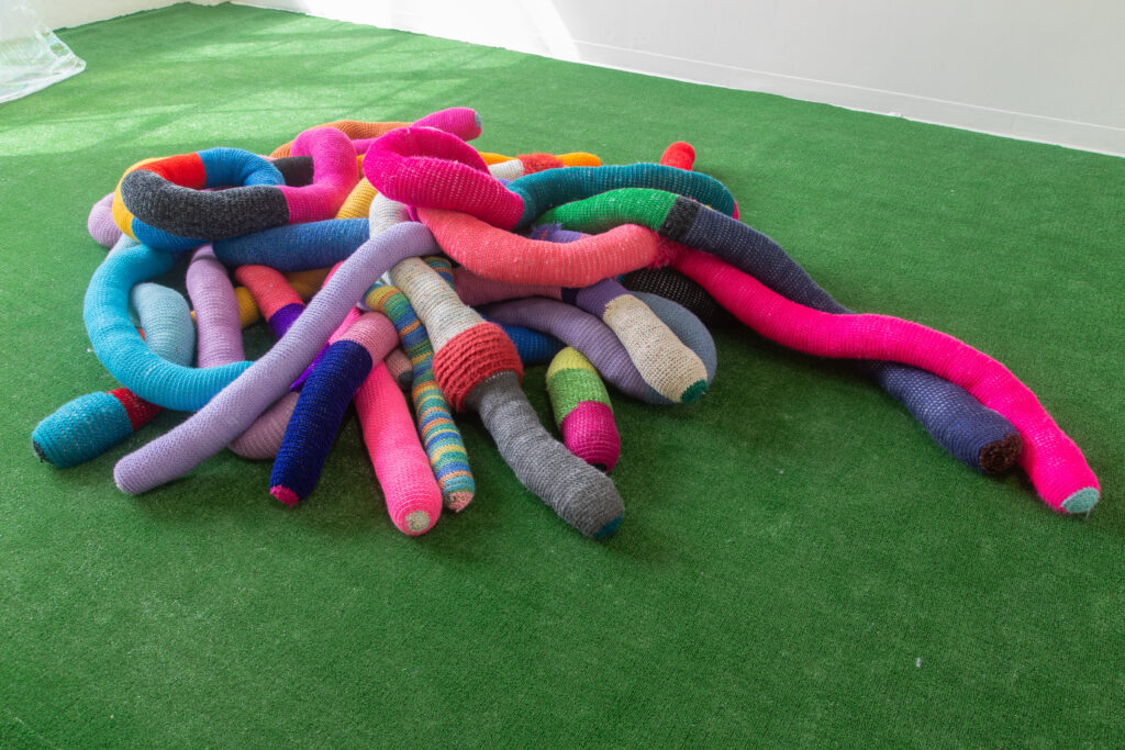 pile of large tube-shaped knit pillows
