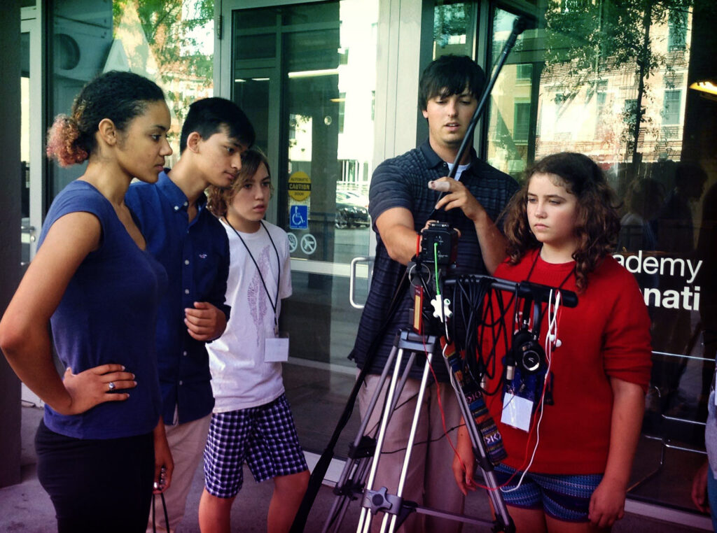 youth setting up a camera and tripod outside