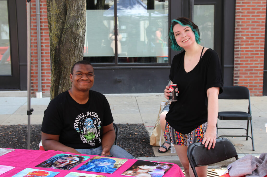two students at outdoor art sale