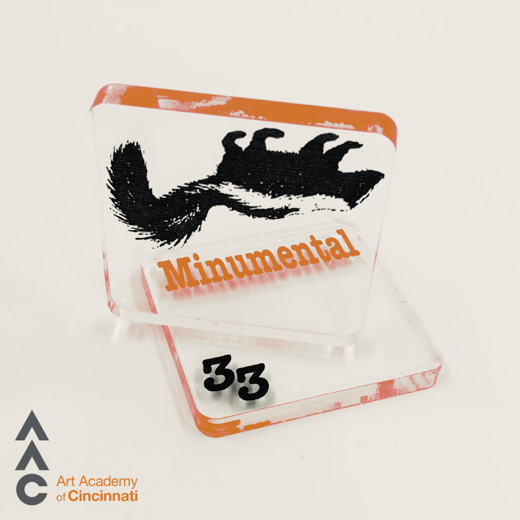 two clear squares. one with upside down skunk and another with the word "minumental" and the number "33"