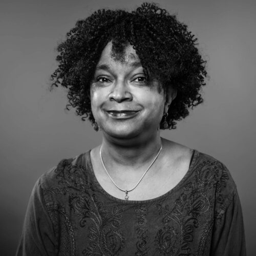 Woman with curls and earrings smiling