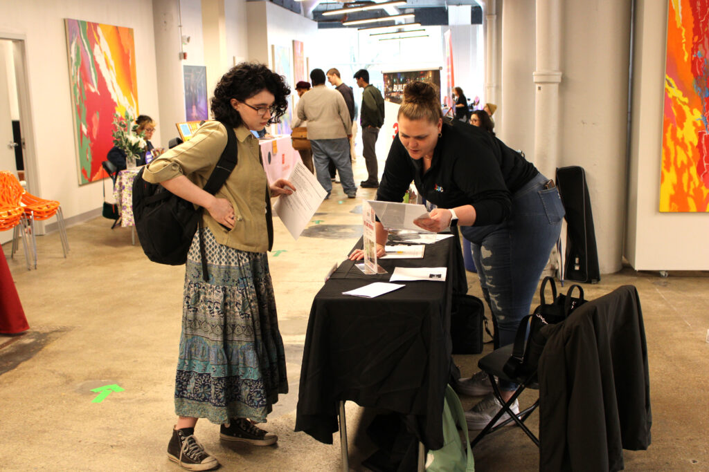 A student speakers with a prospective employer at the Spring 2023 Career Fair in SITE1212 at the Art Academy of Cincinnati.