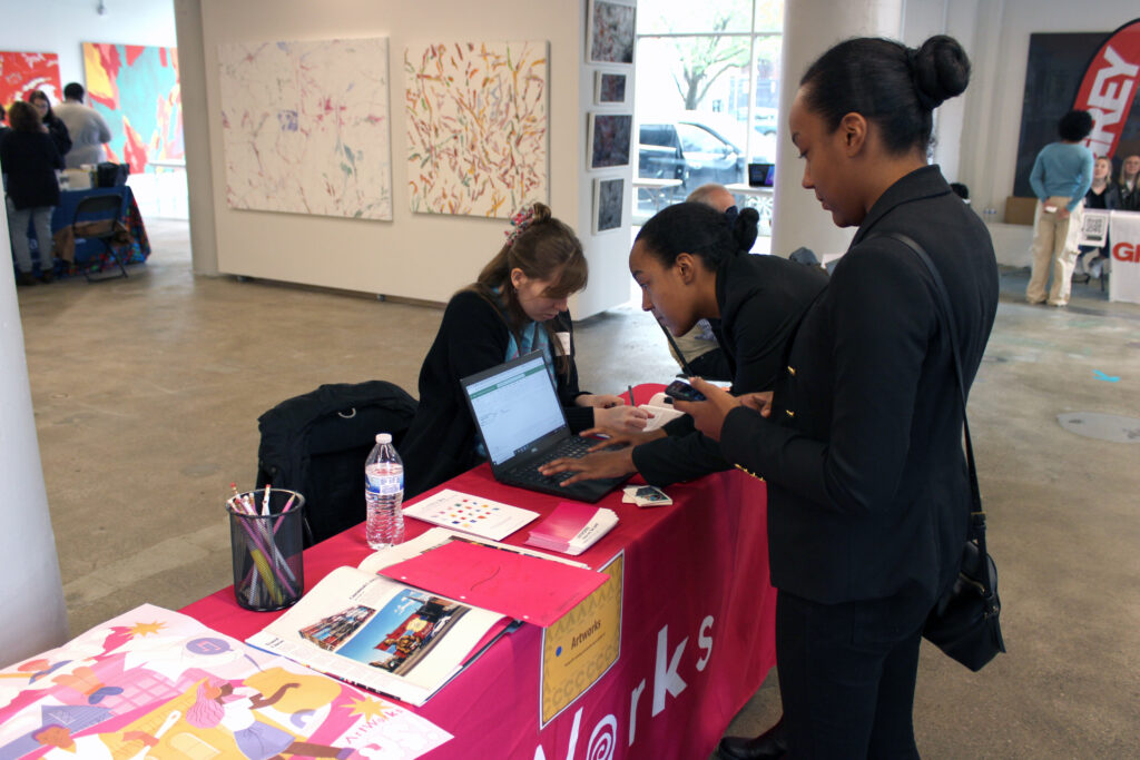 two you people typing on a computer at a career fair