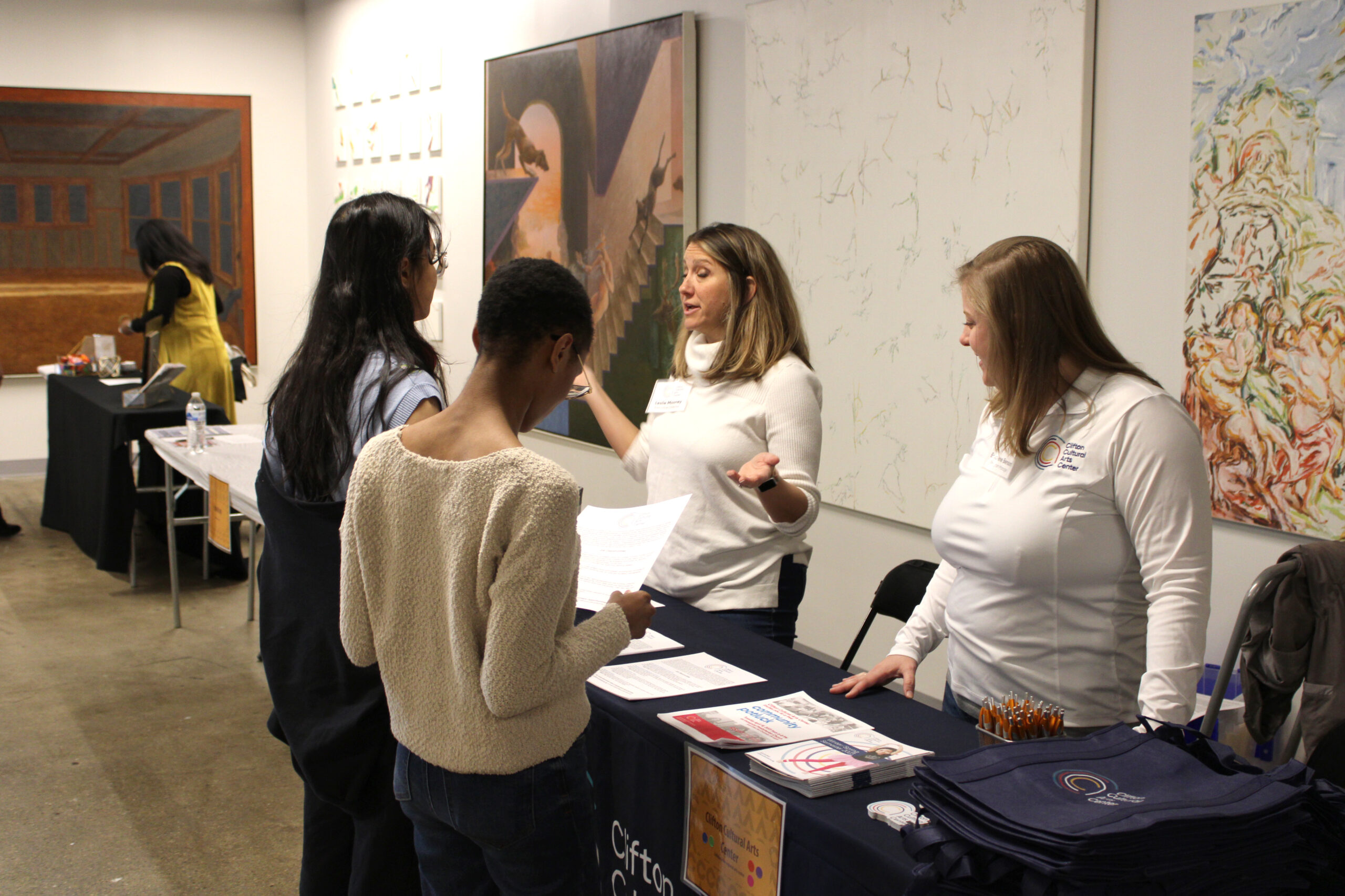 Two students get information from prospective employers at the Spring 2023 Career Fair in SITE1212 at the Art Academy of Cincinnati.