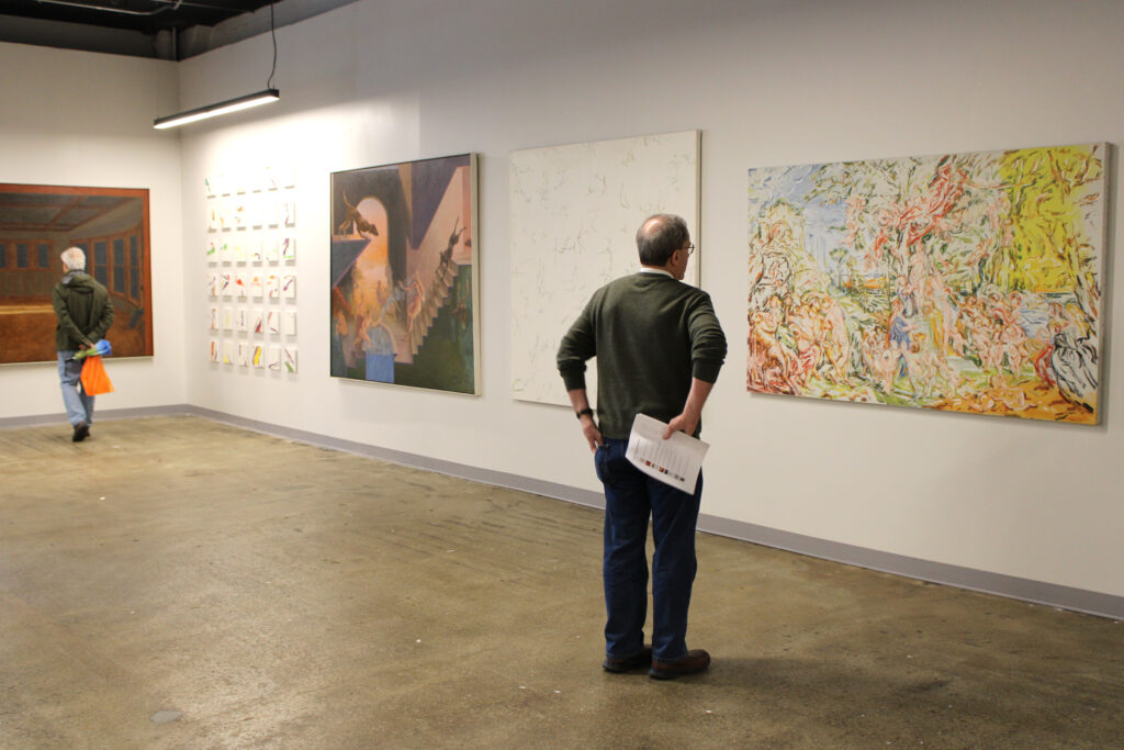 Visitors view artwork as part of Stewart Goldman's Cross Currents exhibition in SITE1212 at the Art Academy of Cincinnati.