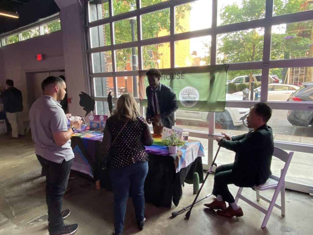 A vendor speaks with guests at the HRC Project Rainbow Fashion Show in SITE1212 at the Art Academy of Cincinnati.
