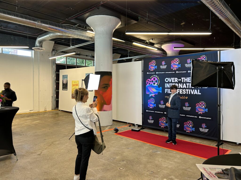 A film-goer poses for a picture at the photobooth at the 2023 OTR Film Festival in SITE1212 at the Art Academy of Cincinnati.