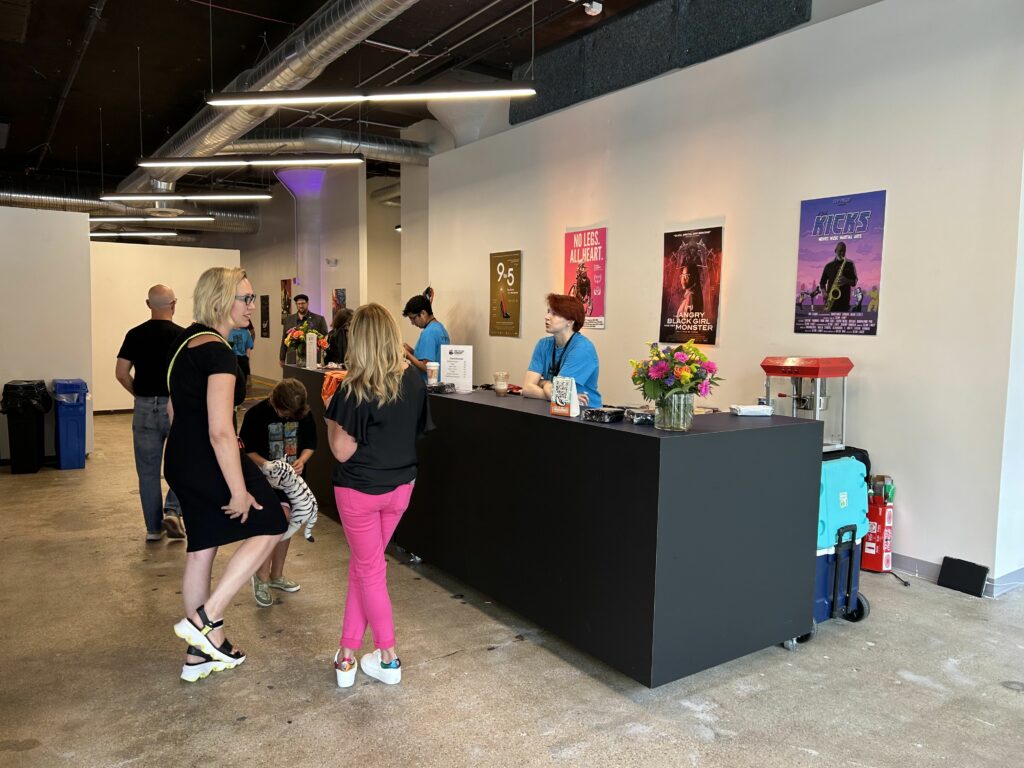 A group awaits their order at a concession stand at the 2023 OTR Film Festival in SITE1212 at the Art Academy of Cincinnati.