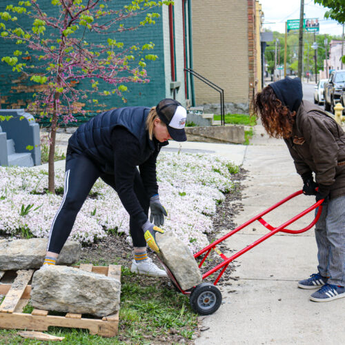 two people removing bricks from a pallete