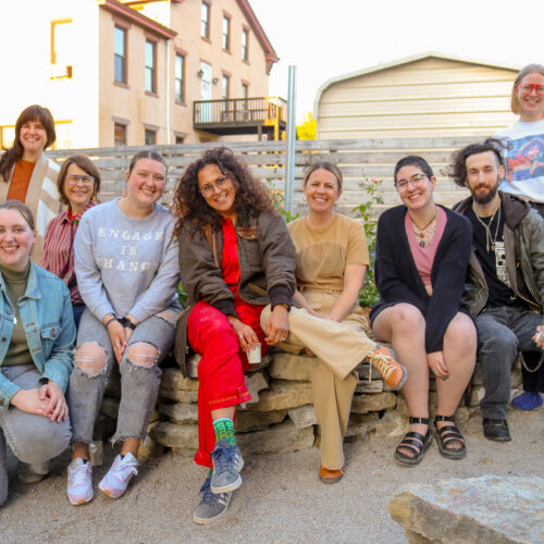 artist sitting with volunteers