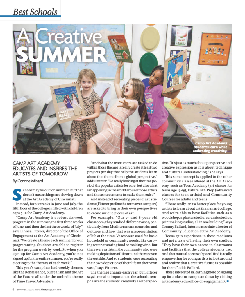 Three students pose while holding their artwork.